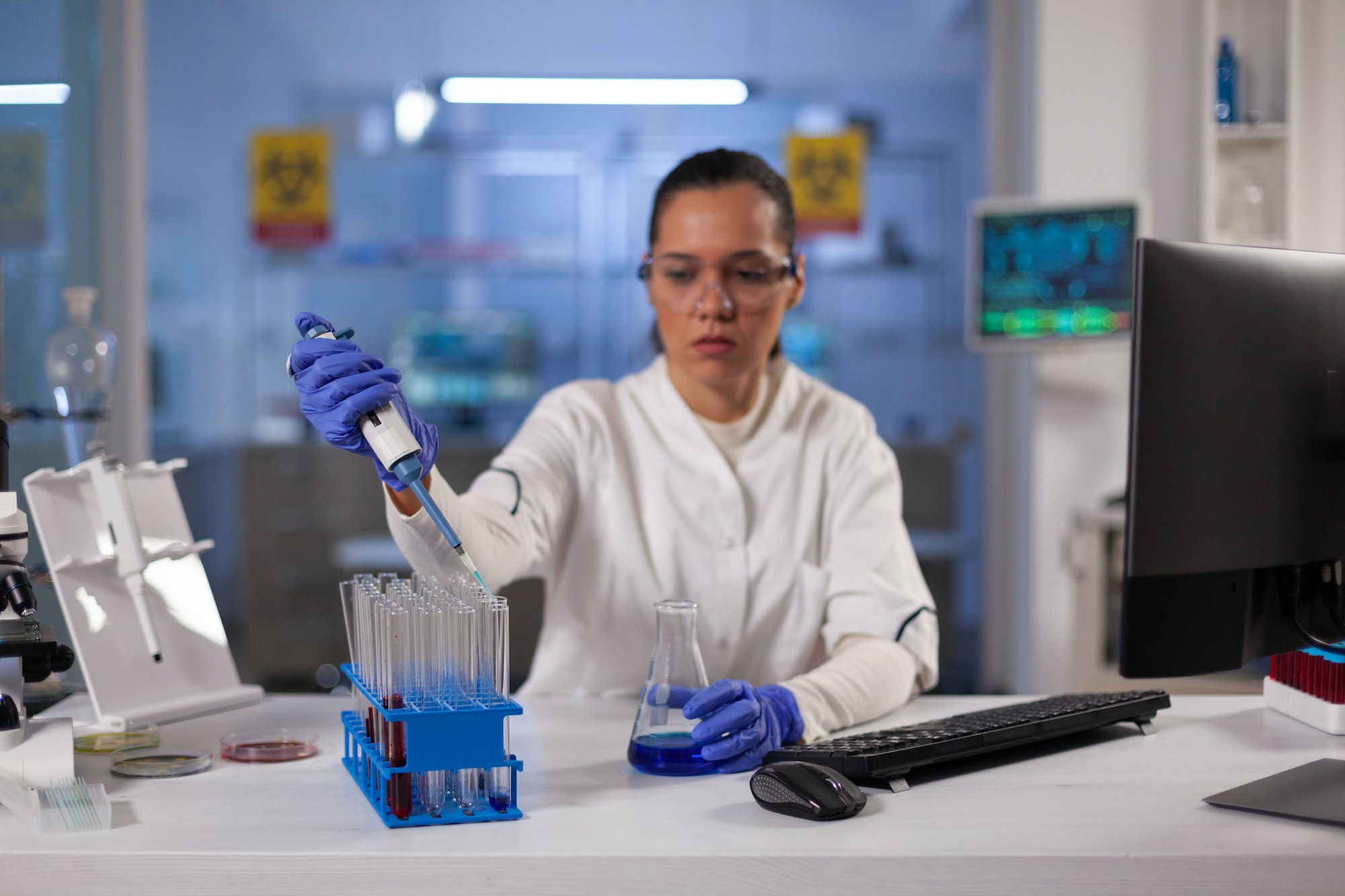 Professional laboratory worker using pipette for jar